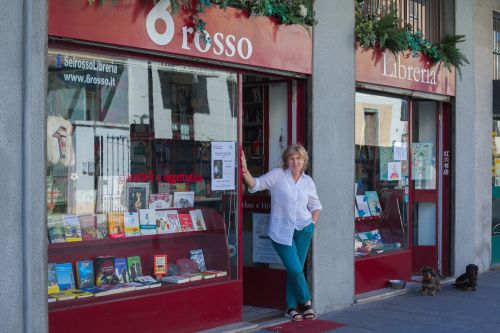 6ROSSO, la libreria dello scambio culturale (Via Albertini 6, Chinatown)
Pathos e Himeros sono le parole incise sulla porta: ricordo della vita precedente del luogo (un punto Einaudi chiuso in un momento di transizione della zona) e la forza dell’attuale proprietaria, Sabina. All’interno c’è un piccolo  angolo  bookcrossing  di  soli  libri  in  lingua  originale,  segno  della  vita  precedente  di  Sabina  che  ha vissuto  tra  Bolzano,  Vienna,  Londra.  Oggi  studia  arabo  e  la libreria  che  gestisce  è  in  Chinatown.  I  suoi aiutanti sono i due bassottini che stazionano sulla soglia.